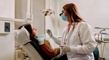 A dentist sitting chairside with a patient