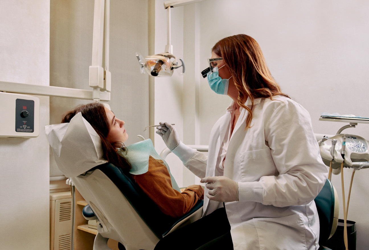 A dentist sitting chairside with a patient