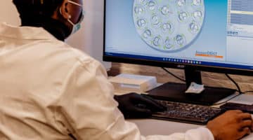 A man looking at crowns being milled digitally through CAD