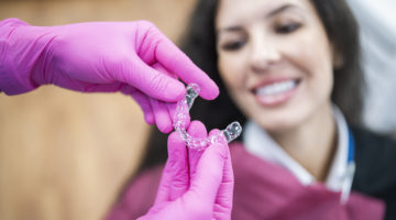 Orthodontist giving a happy patient dental aligners.