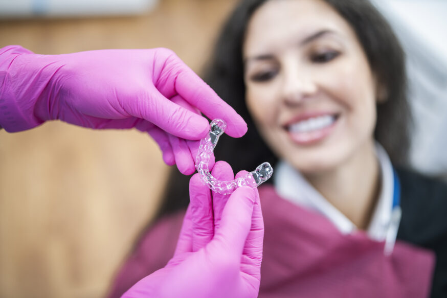 Orthodontist giving a happy patient dental aligners.